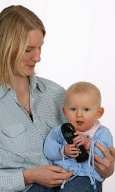 Mutter mit Baby und Schnurlostelefon